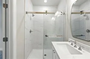 a bathroom with a sink shower and a mirror
