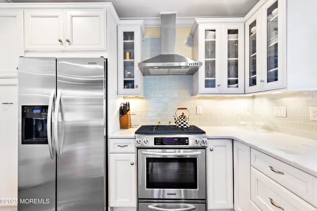 a kitchen with stainless steel appliances granite countertop a refrigerator a stove and a sink with cabinets