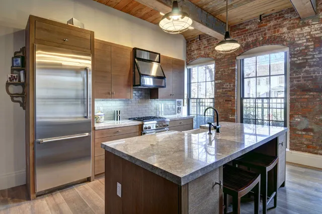 a kitchen with granite countertop a refrigerator and a sink