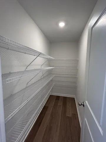 an empty room with wooden floor chandelier and windows