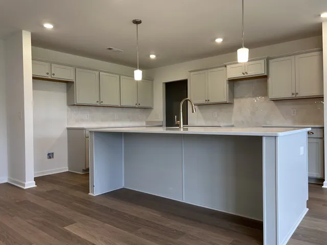 a kitchen with kitchen island a counter space a sink and a stove