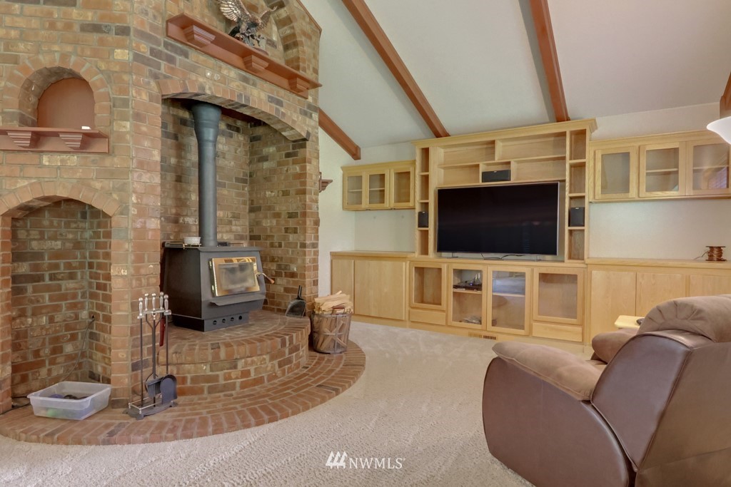 25308 Brooks Road East Orting, WA 98360 - Photo 16 of 40 a living room with furniture a flat screen tv and a fireplace