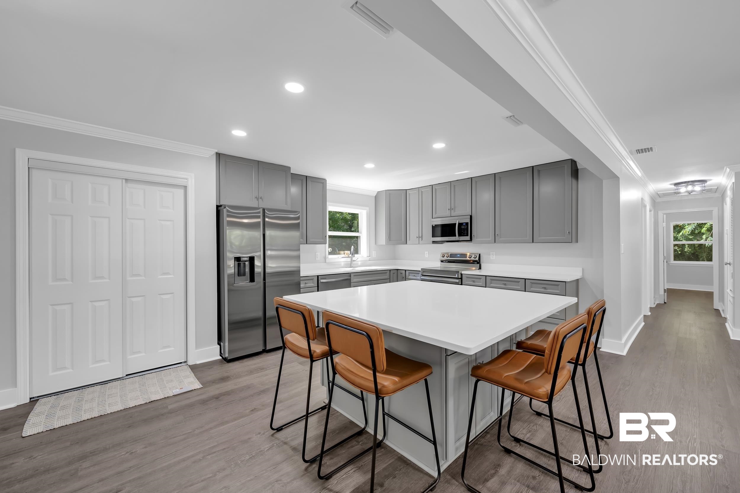2712 Shelton Beach Rd Extension Mobile, AL 36613 - Photo 8 of 24 Modern kitchen featuring gray cabinetry, white countertops, stainless steel appliances, a center island, and wood-finish flooring