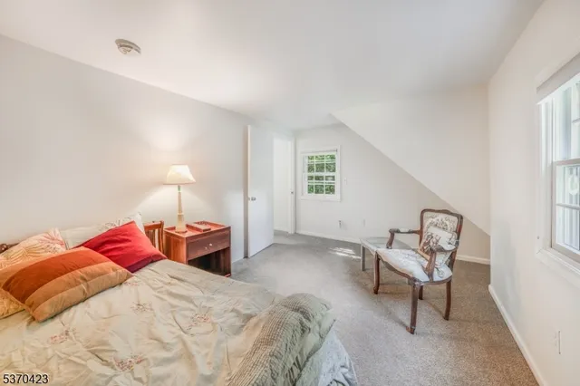 a bedroom with a bed chair and window