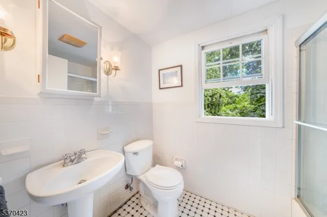 a bathroom with a toilet a sink and a window