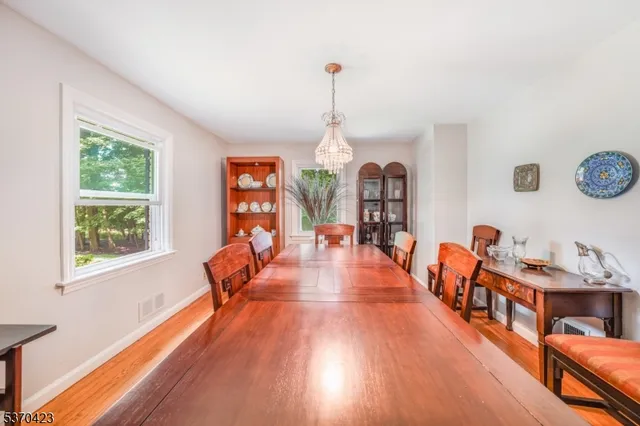 a dining room with wooden floor and a chandelier