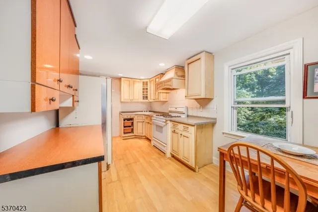 a large kitchen with stainless steel appliances granite countertop a stove a sink and a refrigerator
