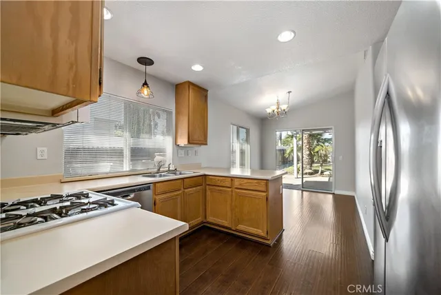 a kitchen with granite countertop a sink stove and refrigerator