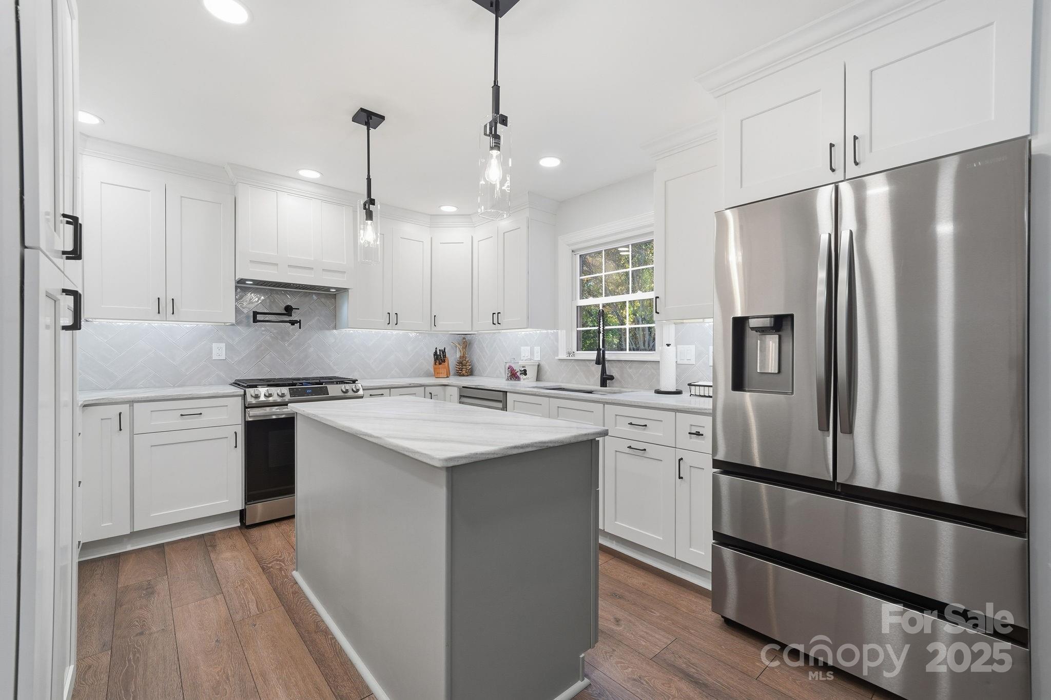 6600 Shaftesbury Road Charlotte, NC 28270 - Photo 12 of 42 a kitchen with stainless steel appliances granite countertop a sink a stove a refrigerator and island with wooden floor
