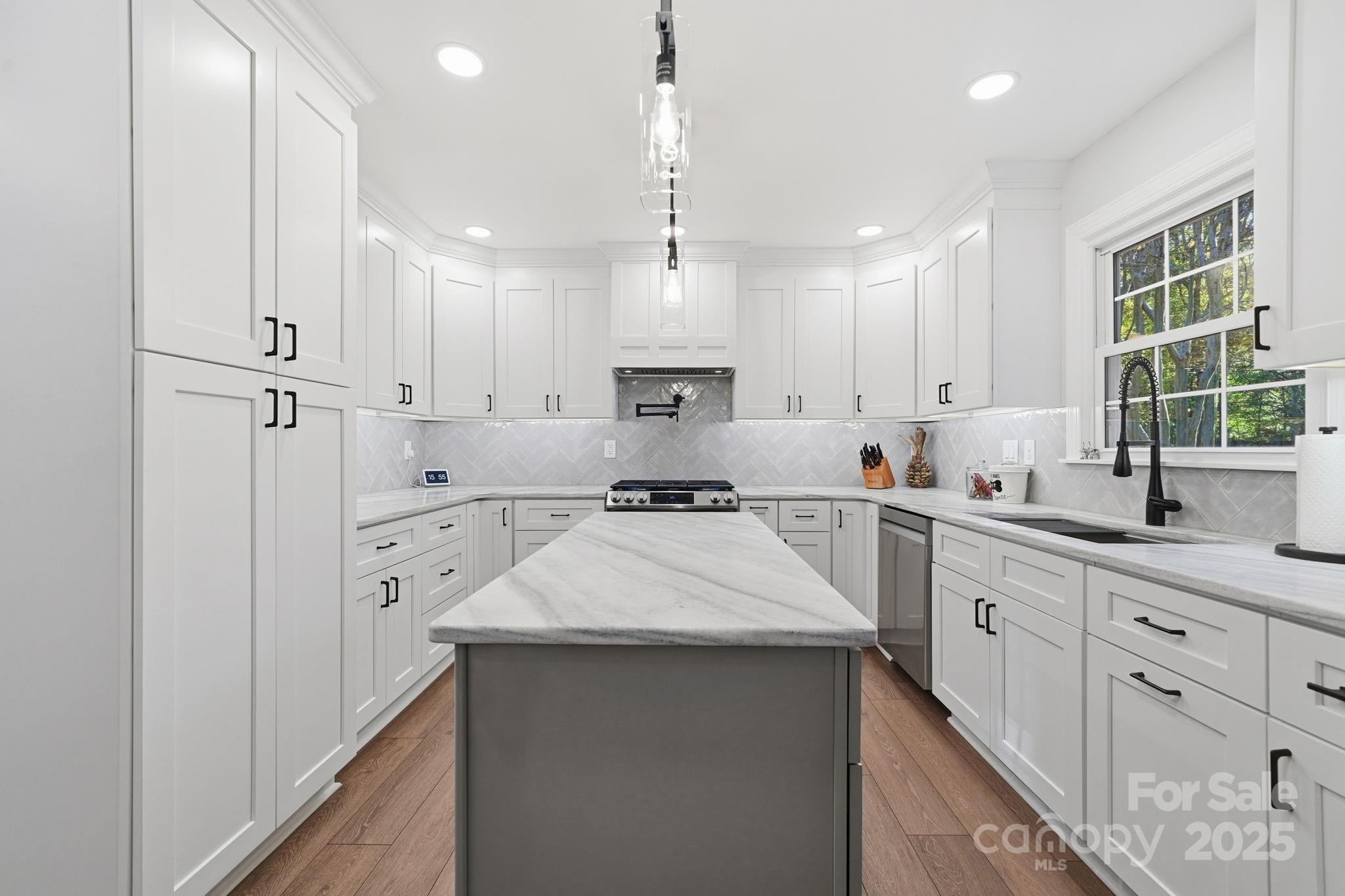 6600 Shaftesbury Road Charlotte, NC 28270 - Photo 13 of 42 a large kitchen with kitchen island white cabinets and stainless steel appliances