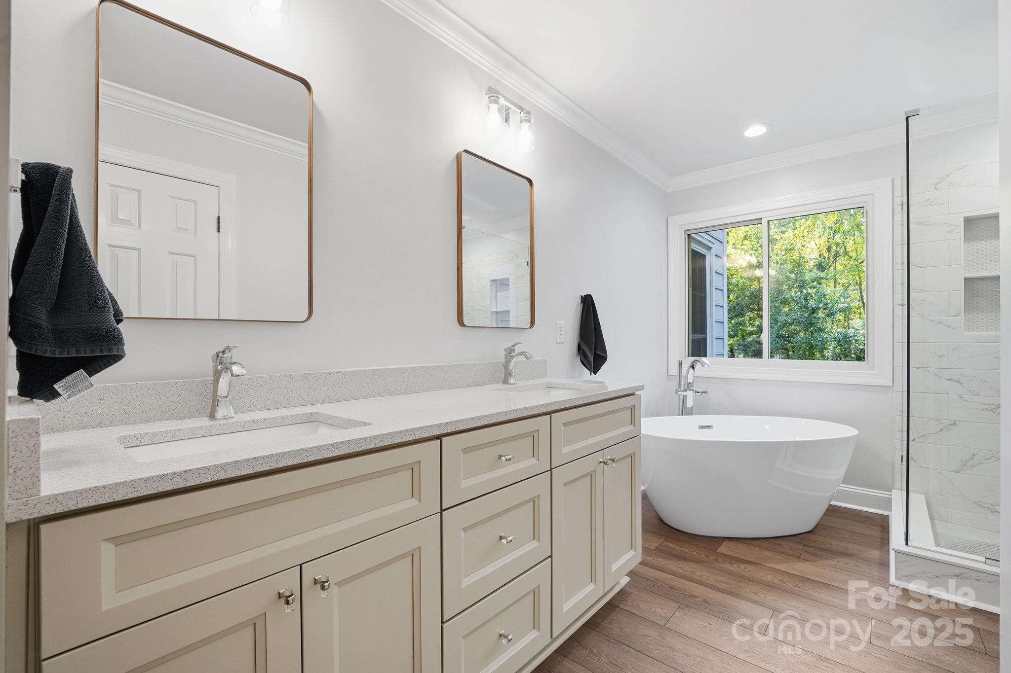 6600 Shaftesbury Road Charlotte, NC 28270 - Photo 25 of 42 a bathroom with a double vanity sink a mirror and a bathtub