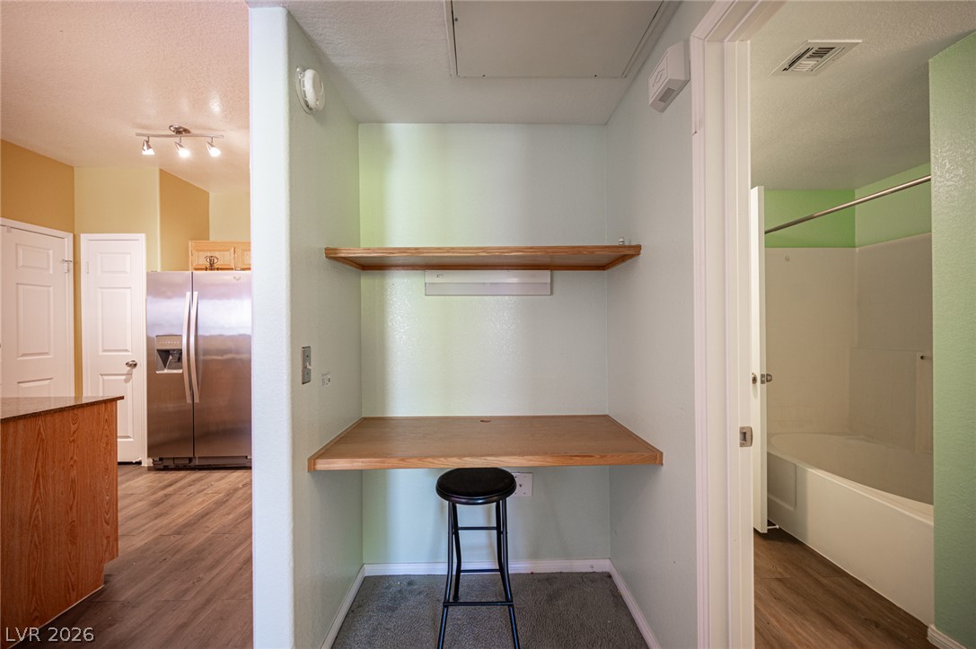 10550 West Alexander Road, Unit 2014 Las Vegas, NV 89129 - Photo 20 of 35 Functional built-in desk area with floating shelves provides a dedicated workspace adjacent to modern kitchen amenities.