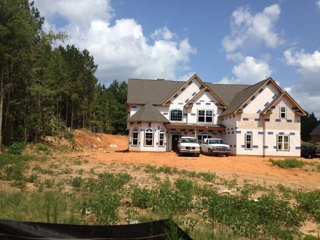 a view of a house with a big yard and large trees