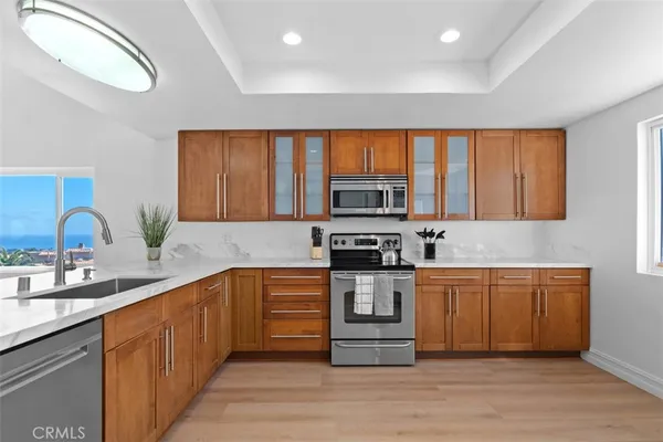 a kitchen with stainless steel appliances a sink cabinets and wooden floor