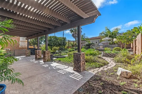 a view of a patio with plants and chairs under an umbrella