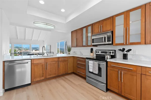 a kitchen with stainless steel appliances granite countertop a stove a sink and a microwave
