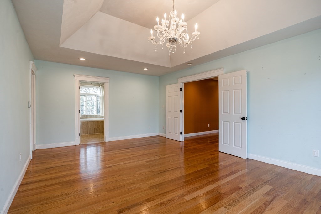 50 Corn Road Bolton, MA 01740 - Photo 19 of 40 a view of an empty room with wooden floor and a window