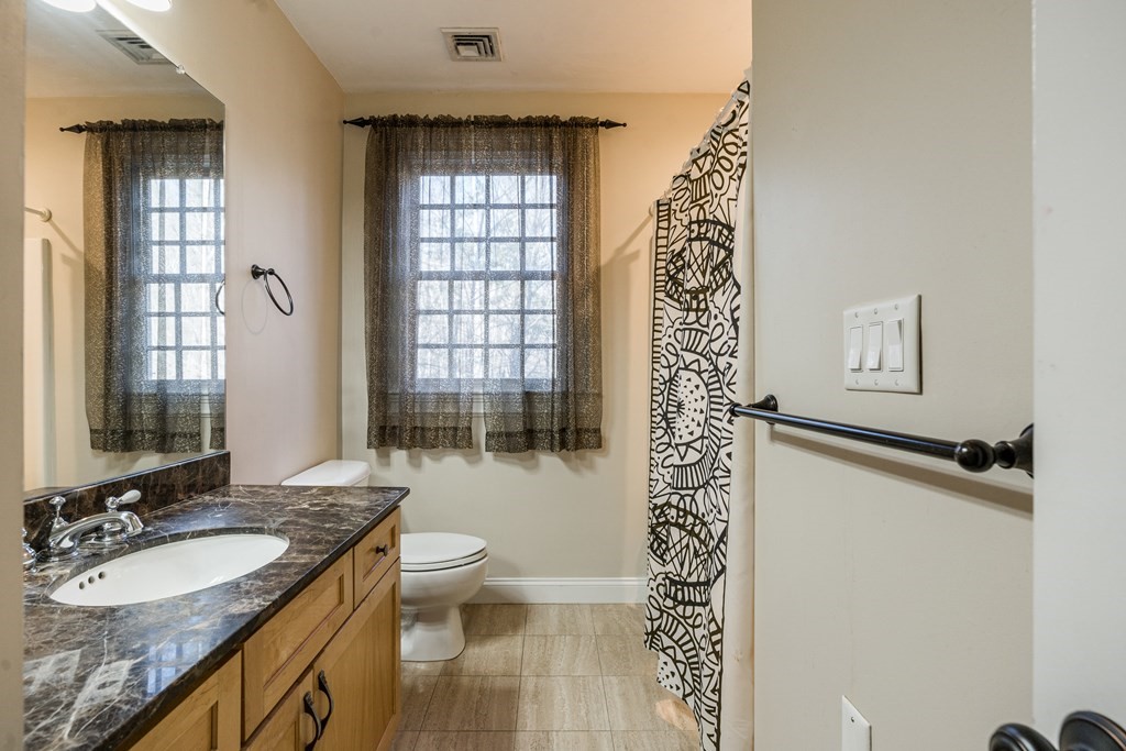 50 Corn Road Bolton, MA 01740 - Photo 27 of 40 a bathroom with a granite countertop sink a toilet and shower