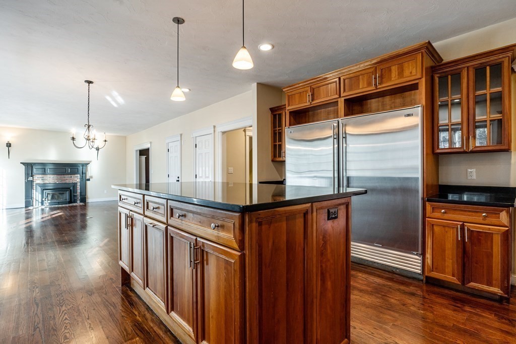 50 Corn Road Bolton, MA 01740 - Photo 6 of 40 a kitchen with stainless steel appliances granite countertop a refrigerator a stove and a wooden floors