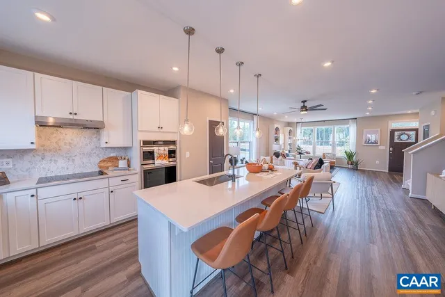 a kitchen with stainless steel appliances a dining table chairs stove and white cabinets