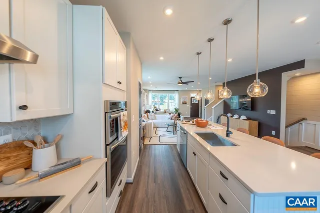 a large kitchen with stainless steel appliances lots of counter space and a wooden floor