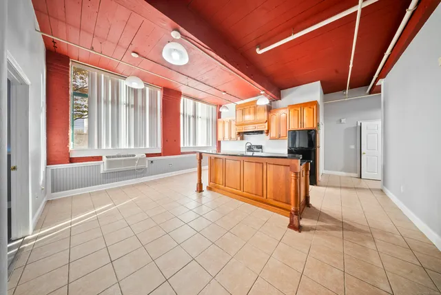a view of kitchen with refrigerator and cabinets