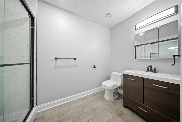 a bathroom with a toilet a sink and mirror