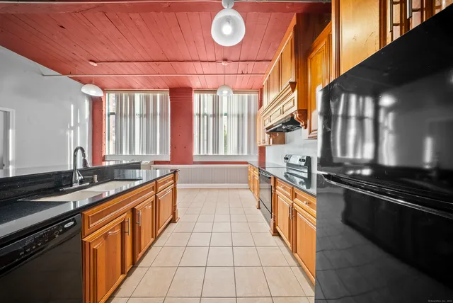 a large kitchen with stainless steel appliances a stove sink and cabinets
