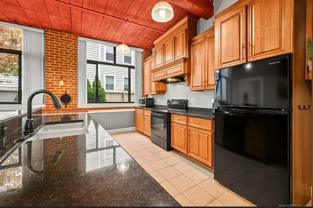 a kitchen with granite countertop stainless steel appliances and wooden cabinets