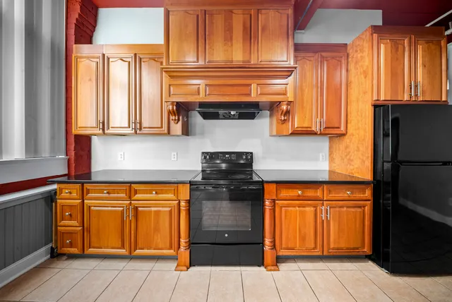 a kitchen with stainless steel appliances granite countertop a refrigerator and a stove top oven