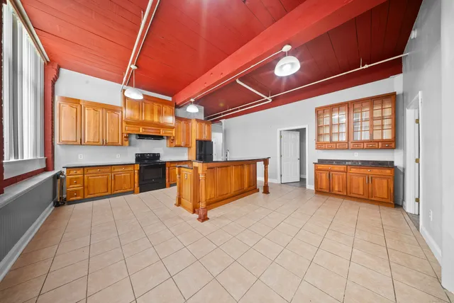 a kitchen with stainless steel appliances kitchen island granite countertop a refrigerator and a sink