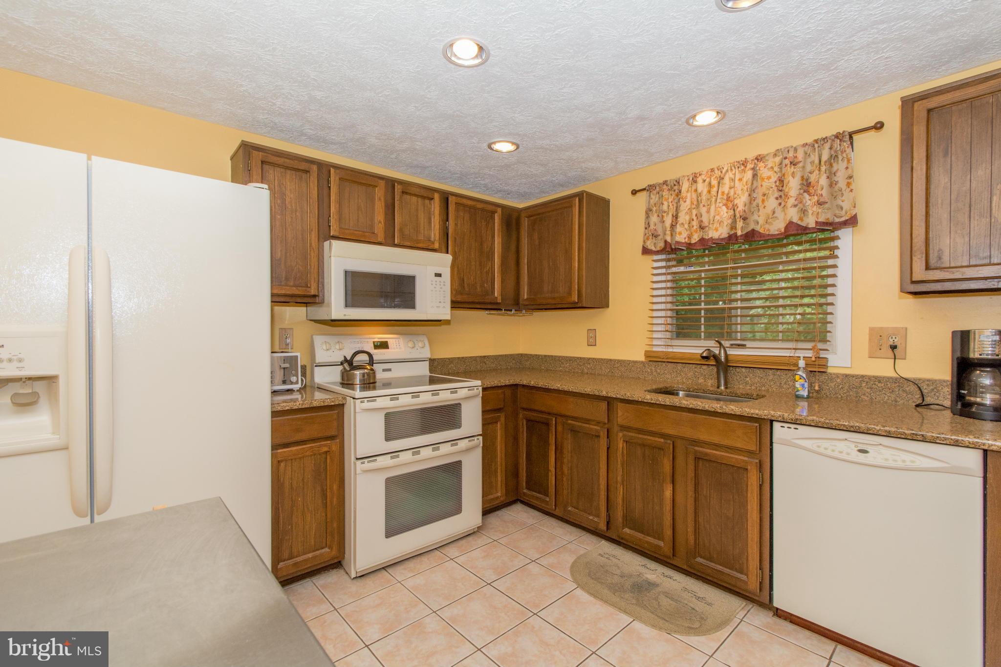 4825 Hawksbury Road Baltimore, MD 21208 - Photo 11 of 29 a kitchen with a sink stove and microwave