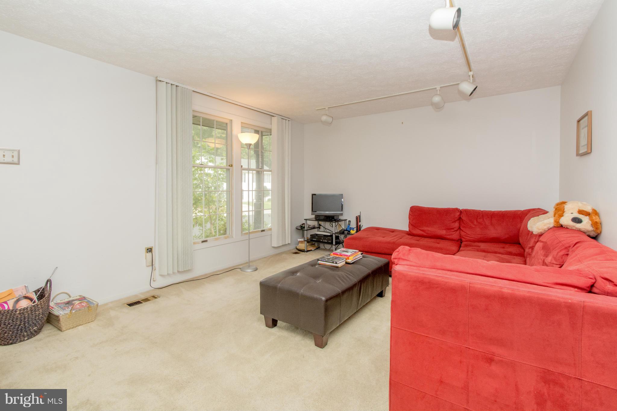 4825 Hawksbury Road Baltimore, MD 21208 - Photo 4 of 29 a living room with furniture a flat screen tv and a window