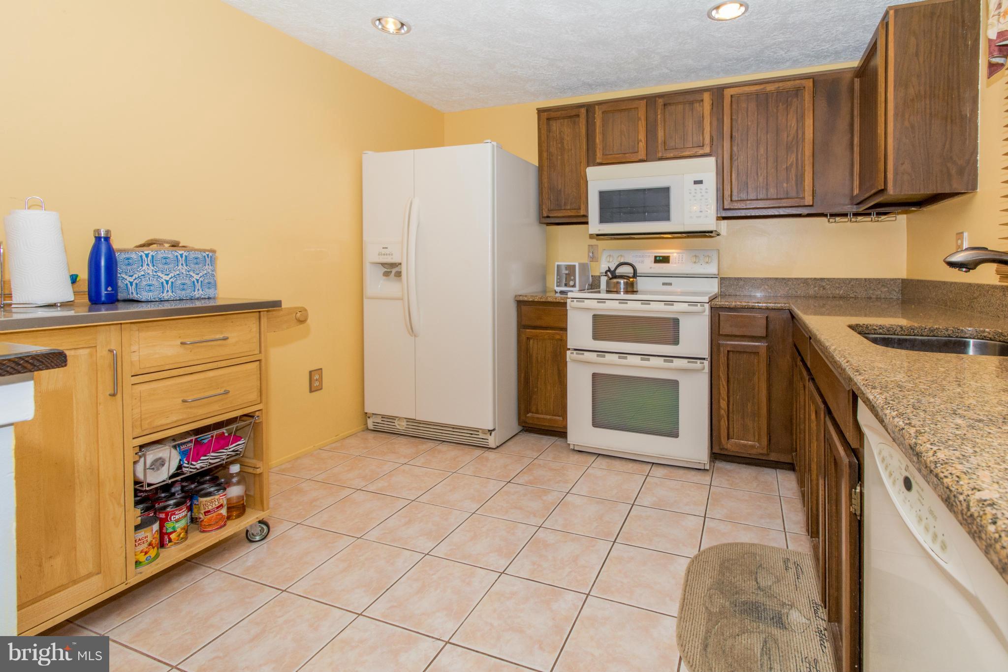 4825 Hawksbury Road Baltimore, MD 21208 - Photo 10 of 29 a kitchen with a stove a sink and a refrigerator