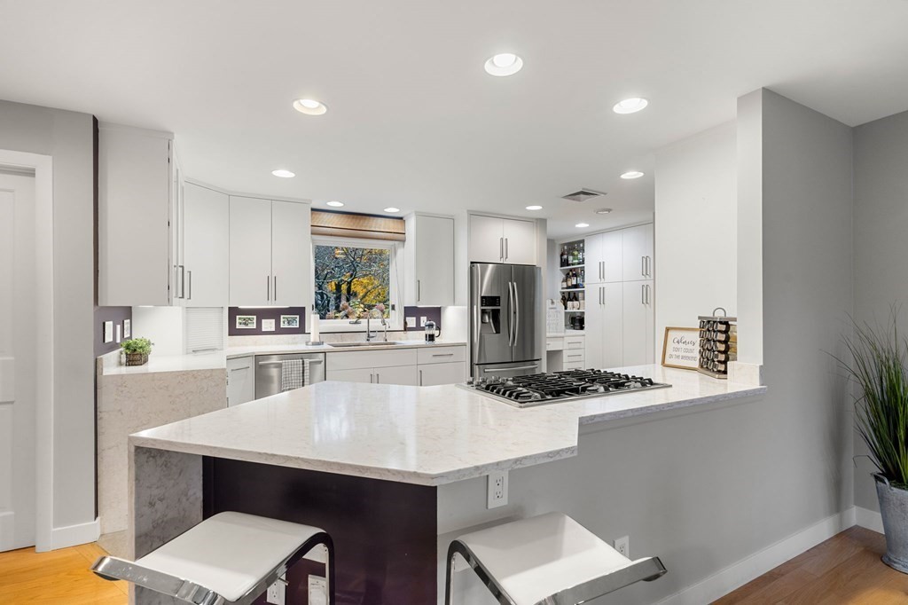 7 Par Brae Grantham, NH 03753 - Photo 10 of 42 a kitchen with stainless steel appliances kitchen island a table chairs and a refrigerator