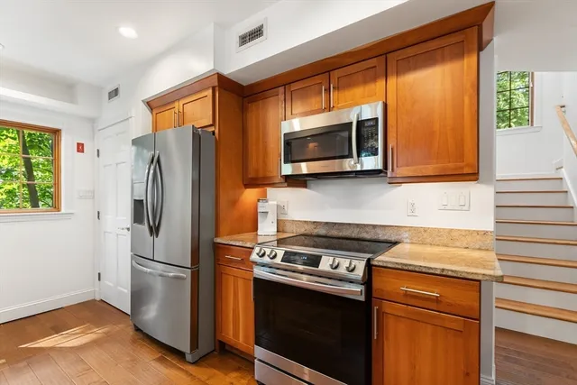 a kitchen with stainless steel appliances granite countertop a refrigerator microwave and sink