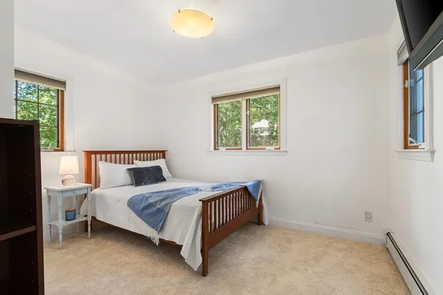 a bedroom with a bed lamp and a window