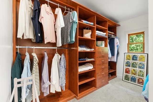a view of walk in closet with clothes and shoes
