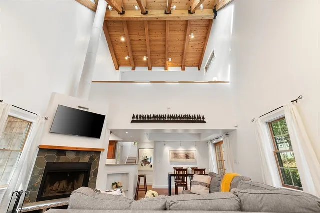 a living room with furniture a fireplace and a flat screen tv