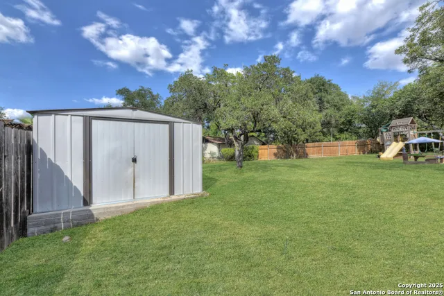 a backyard of a house with table and chairs