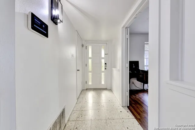 a view of hallway with stairs and wooden floor