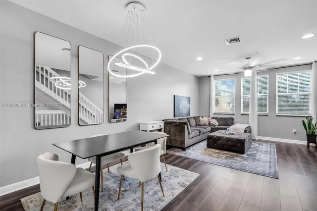 a living room with furniture kitchen view and a large window