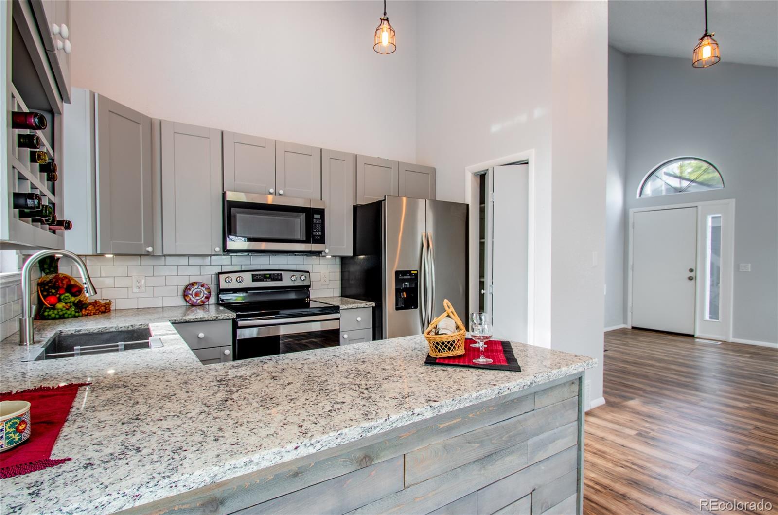13309 Birch Circle Thornton, CO 80241 - Photo 7 of 25 a kitchen with stainless steel appliances kitchen island granite countertop a refrigerator stove and sink