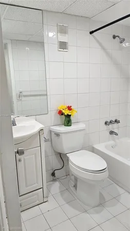 a white toilet sitting next to a bathroom sink and a shower