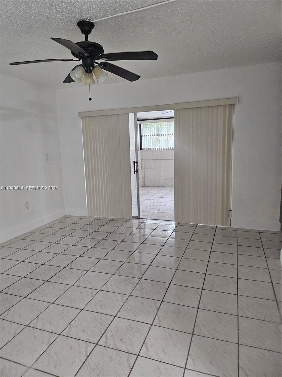 10641 Southwest 108th Avenue, Unit 1H Miami, FL 33176 - Photo 23 of 23 a view of a livingroom with a ceiling fan and window