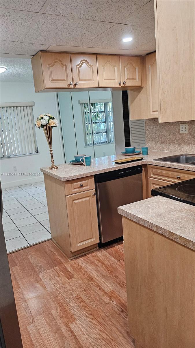 10641 Southwest 108th Avenue, Unit 1H Miami, FL 33176 - Photo 7 of 23 a kitchen with stainless steel appliances granite countertop a sink a stove and a wooden floors