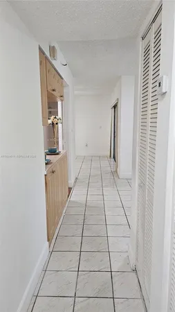a hallway with white walls and tiles