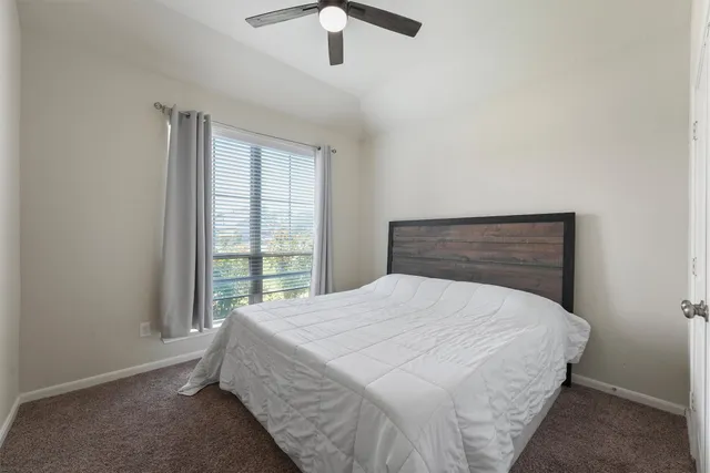 a bed sitting in a bedroom next to a window