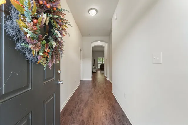 a hallway with wooden floor and potted plant