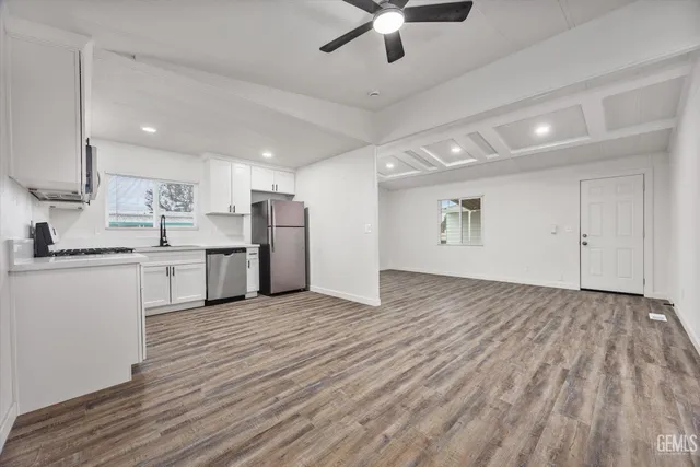 a view of kitchen with wooden floor and electronic appliances